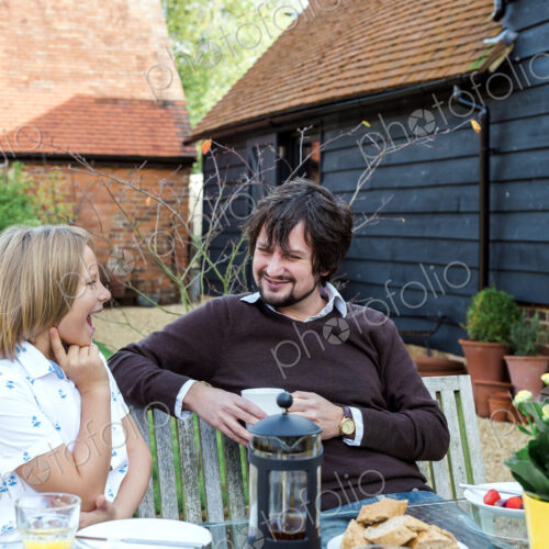 Man and boy having breakfast together at bench outside rural house. Man and boy having breakfast together at bench outside rural house.