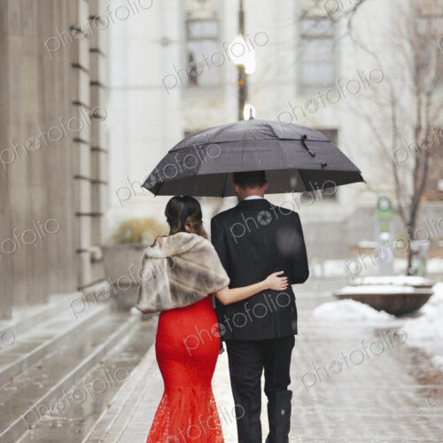 Man and woman, couple in evening dress outside in a city