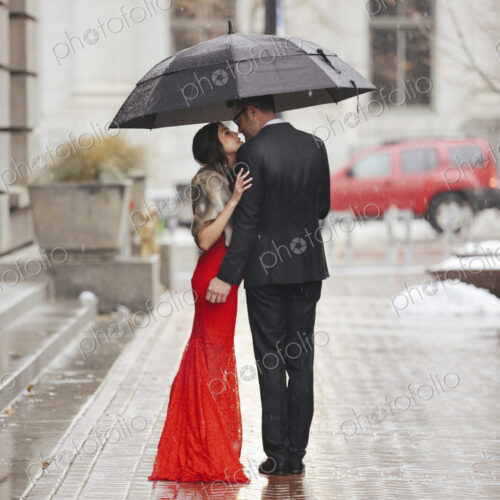 Man and woman, couple in evening dress outside in a city