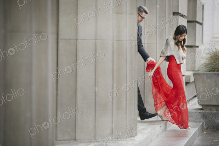 Man and woman, couple in evening dress outside in a city