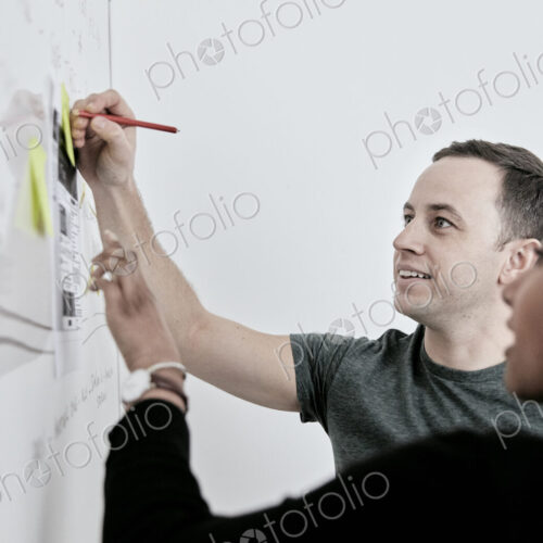 Man and woman discussing work and making notes on a whiteboard. in an office. Man and woman discussing work and making notes on a whiteboard. in an office.