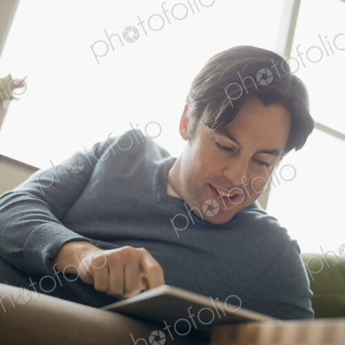 Man at home using electronic tablet Man at home using electronic tablet