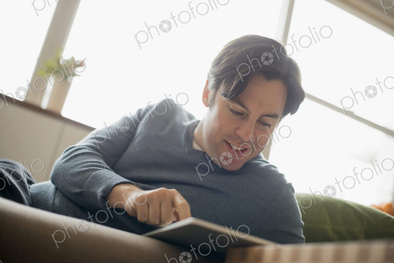 Man at home using electronic tablet