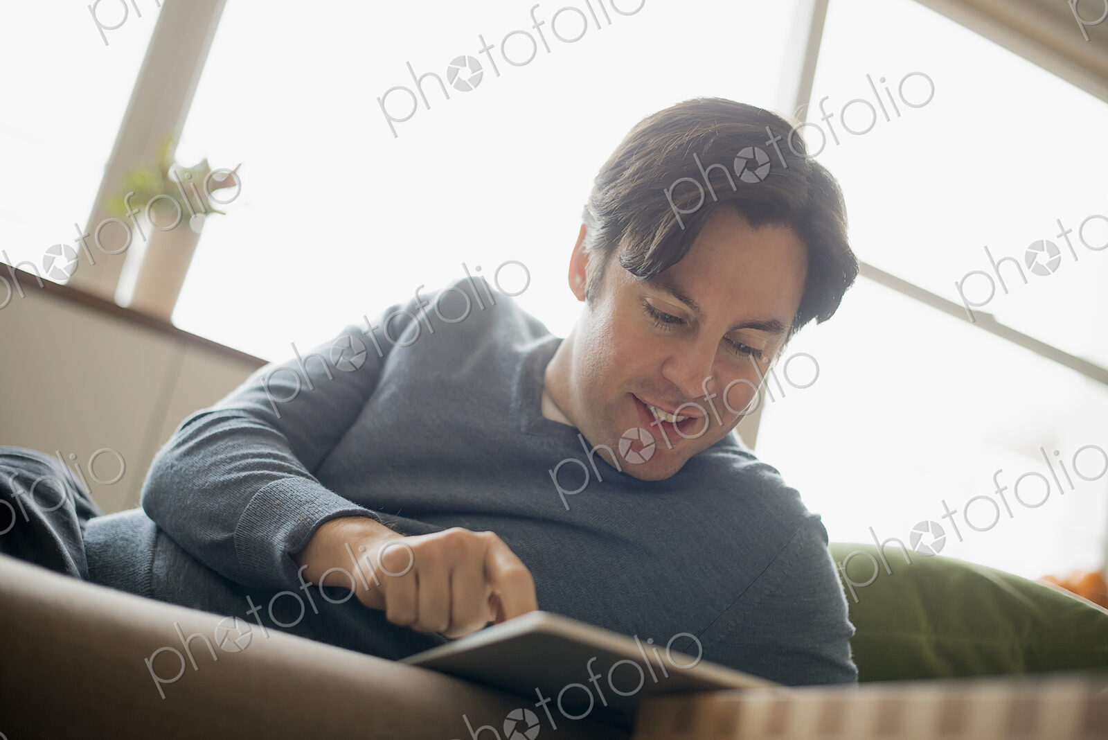 Man at home using electronic tablet