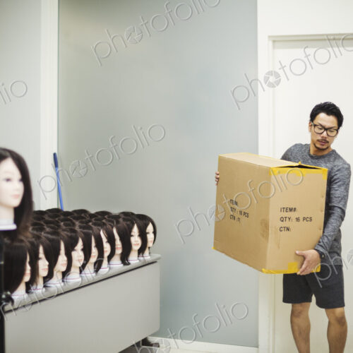 Man carrying a box in a wig shop