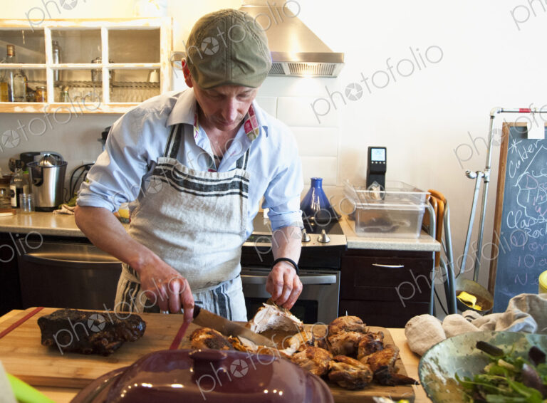 Man carving roasted meat in kitchen