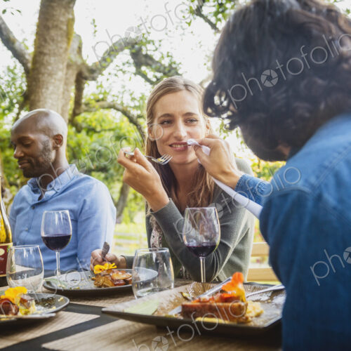 Man feeding food to woman at party outdoors Man feeding food to woman at party outdoors