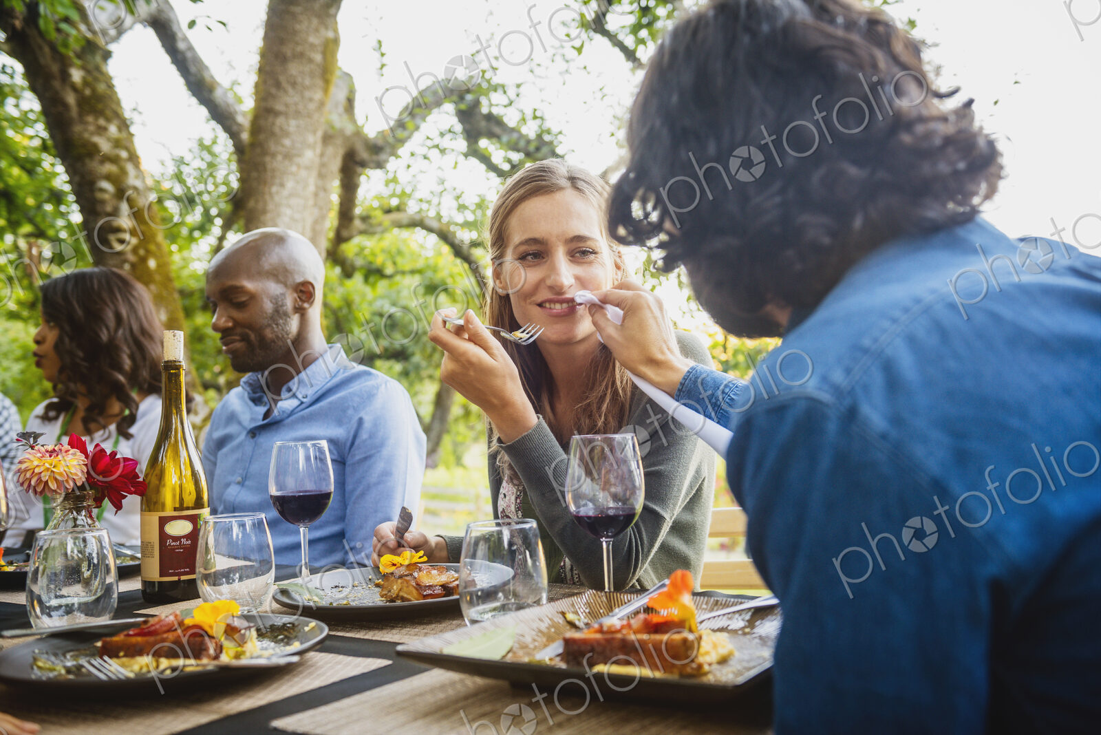 Man feeding food to woman at party outdoors