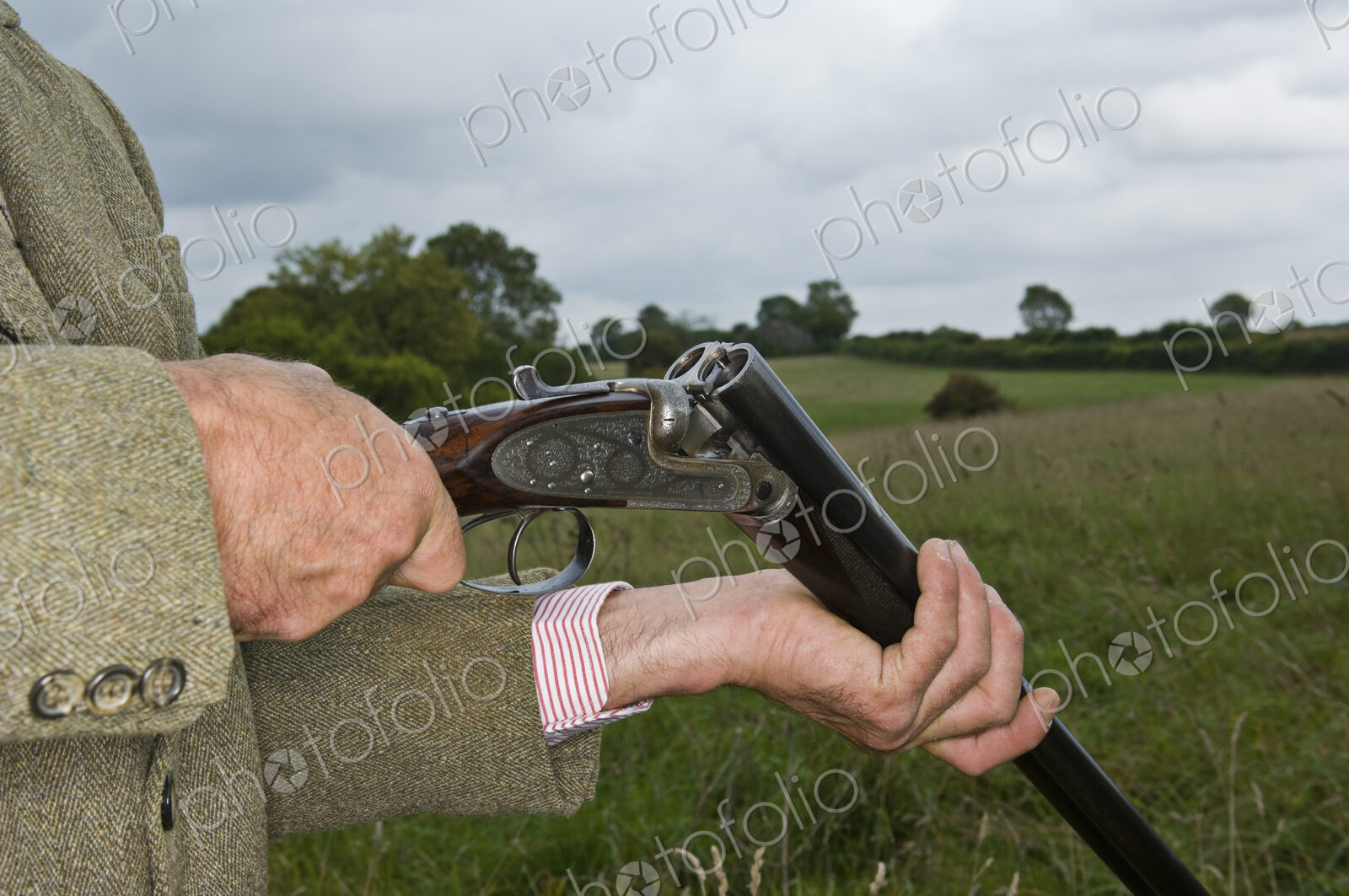 Man holding an open rifle.