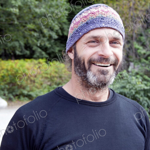 Man in rural area wearing knitted hat.