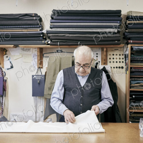Man inspecting fabric in family-run tailor business Man inspecting fabric in family-run tailor business