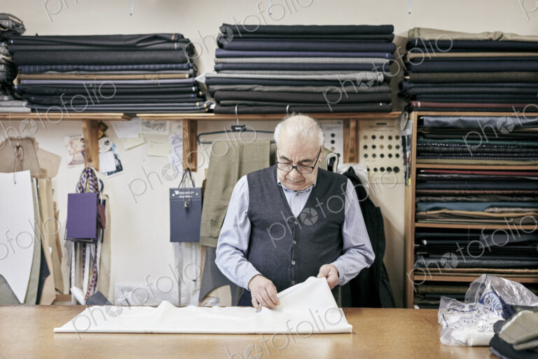Man inspecting fabric in family-run tailor business