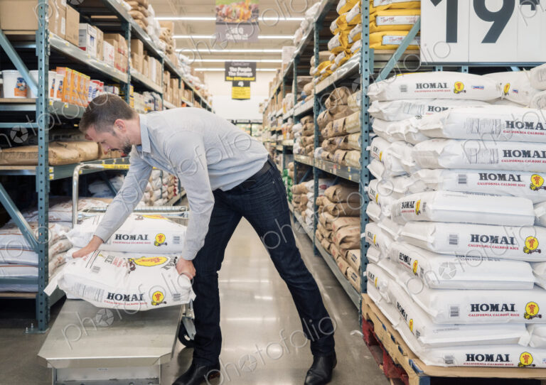 Man loading sack of groceries onto a cart in a wholesaler.