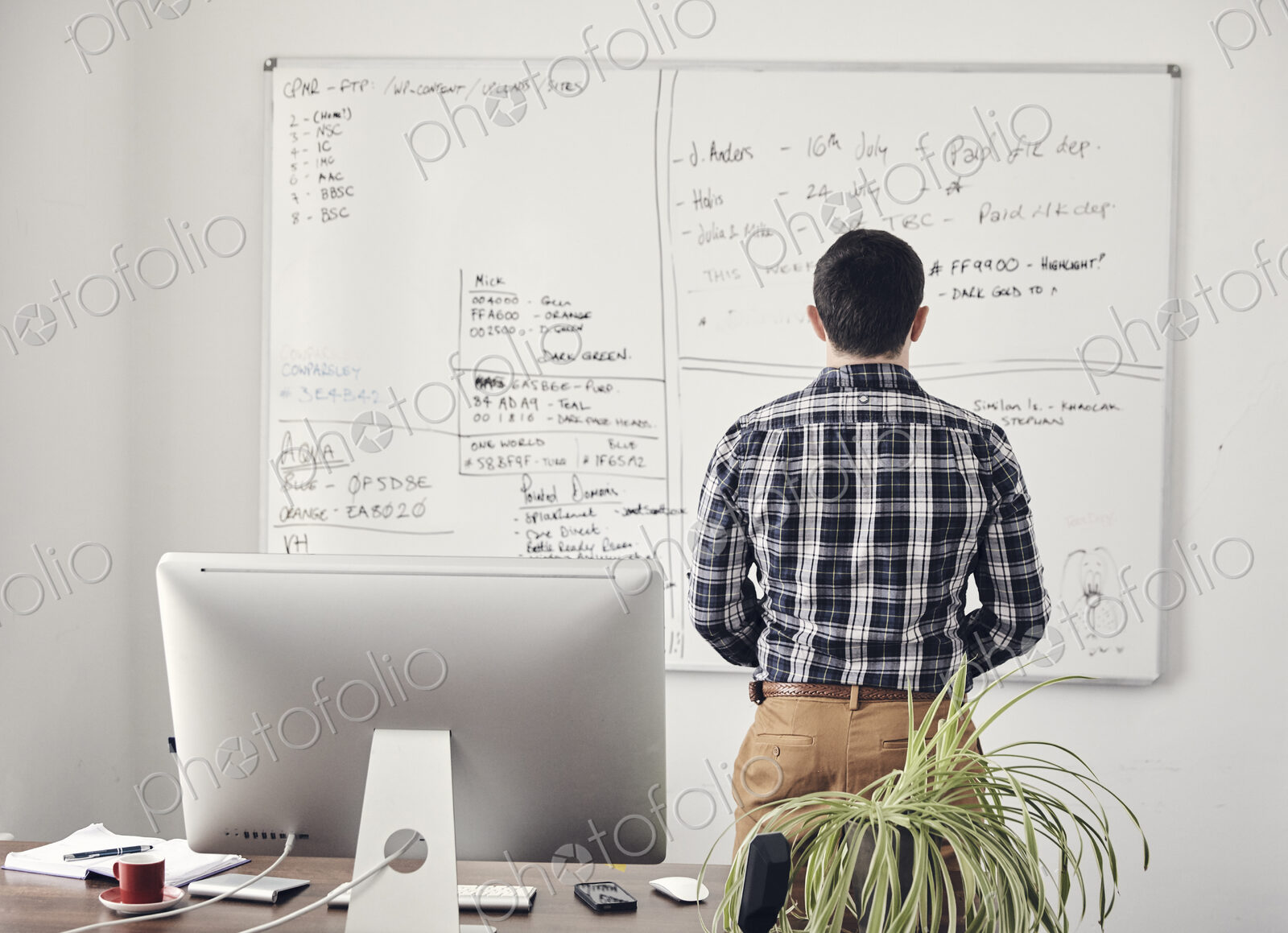 Man looking at a whiteboard in office with his back to camera