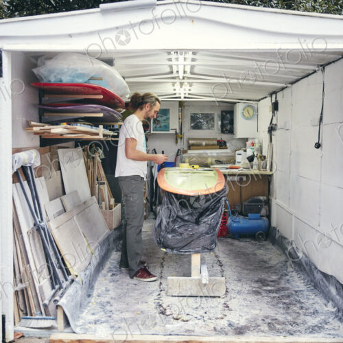 Man making a surfboard in his workshop