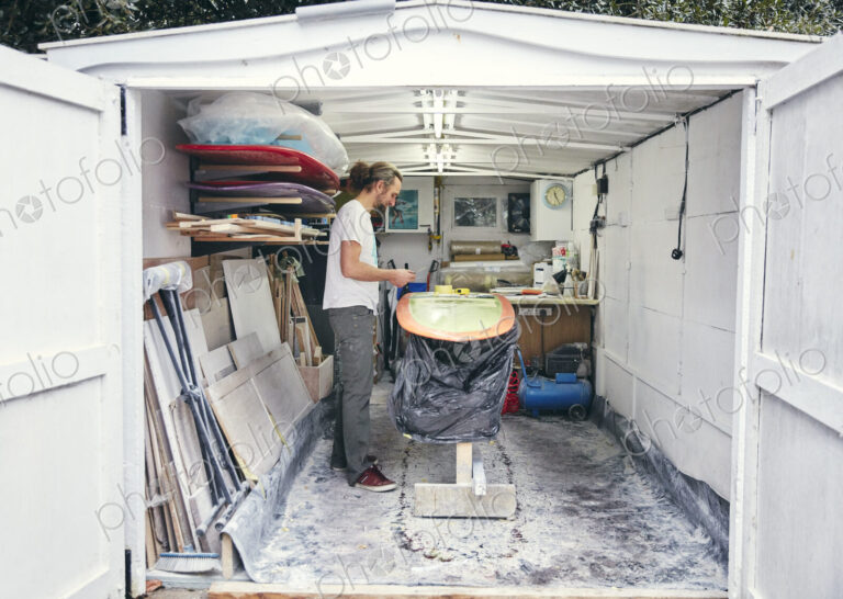 Man making a surfboard in his workshop