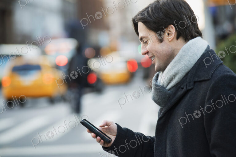 Man on busy street with smartphone