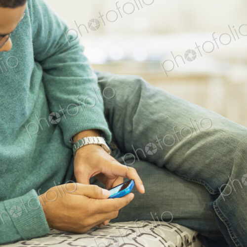 Man relaxing at home with smartphone