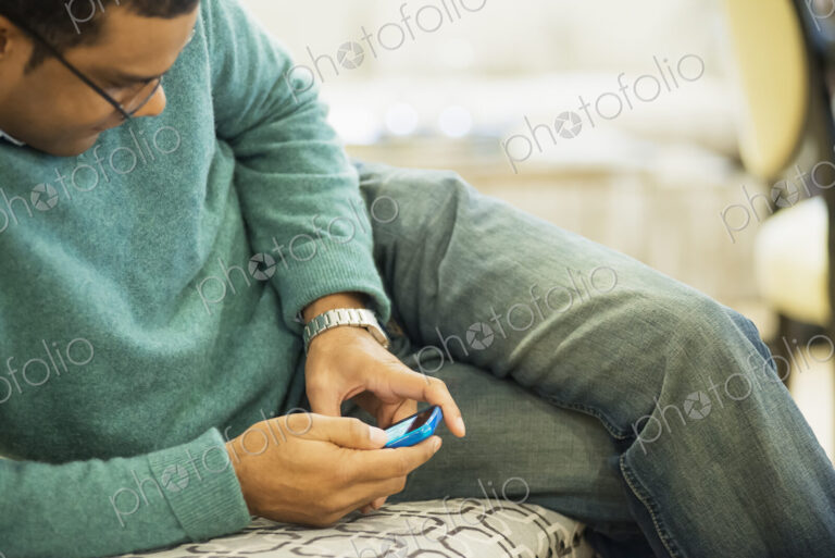 Man relaxing at home with smartphone