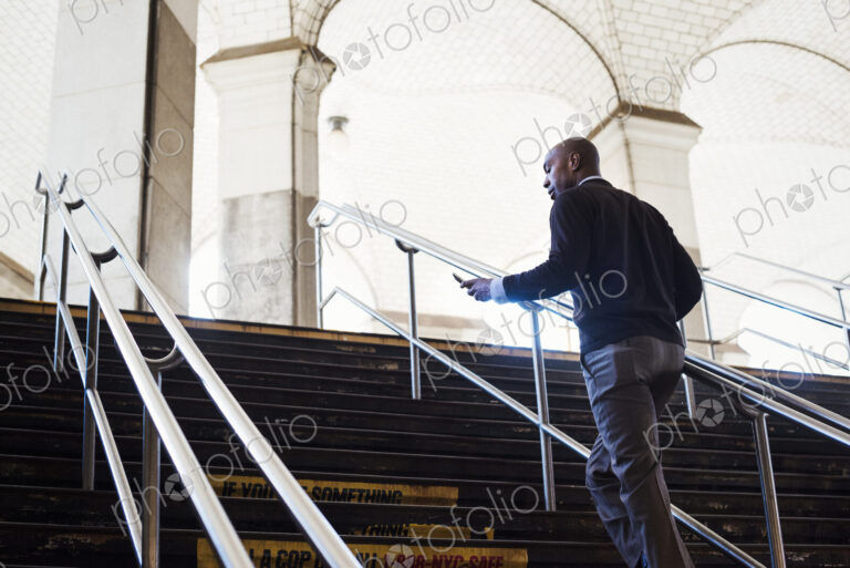 Man running up the steps at a subway station in New York City