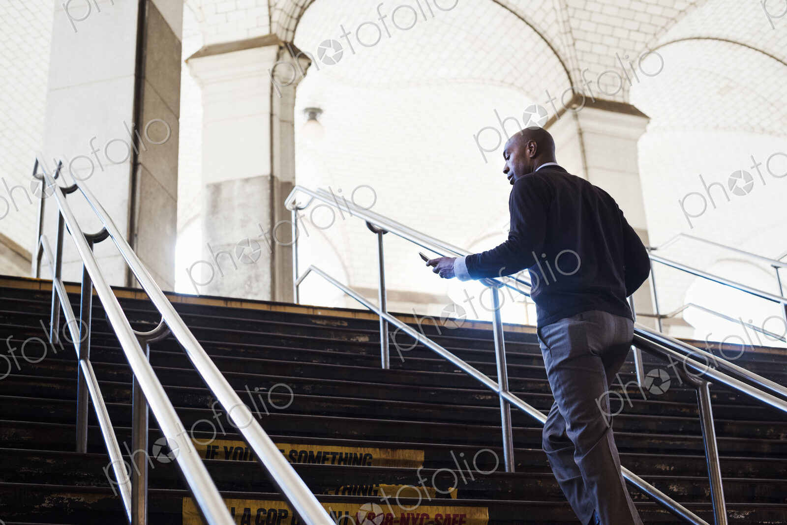 Man running up the steps at a subway station in New York City