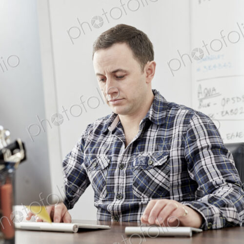 Man seated at a desk using a laptop computer. Man seated at a desk using a laptop computer.