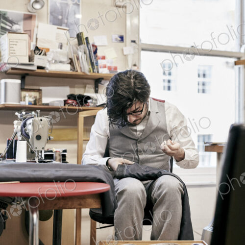Man sewing suit by hand in family tailor business Man sewing suit by hand in family tailor business