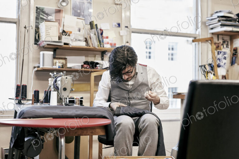 Man sewing suit by hand in family tailor business