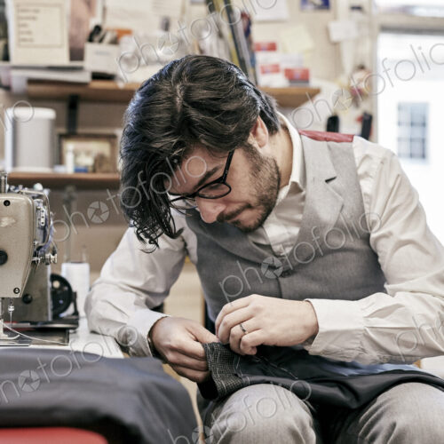Man sewing suit by hand in family tailor business Man sewing suit by hand in family tailor business