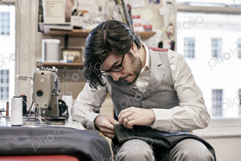 Man sewing suit by hand in family tailor business