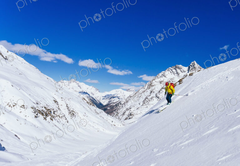 Man skiing on snowy slope in remote landscape
