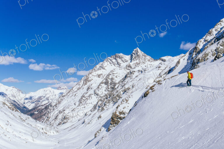Man skiing on snowy slope in remote landscape