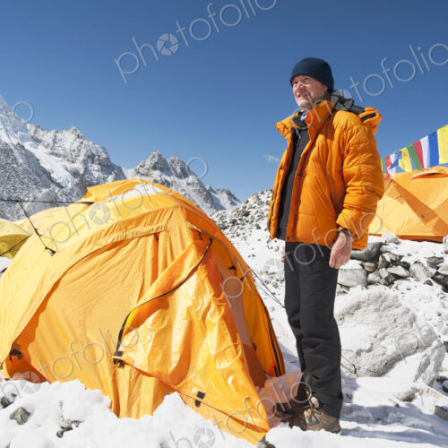 Man standing at base camp tent, Everest, Khumbu region, Nepal Man standing at base camp tent, Everest, Khumbu region, Nepal