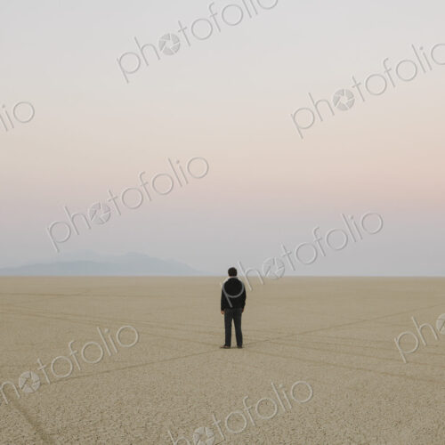 Man standing in vast, desert landscape Man standing in vast, desert landscape