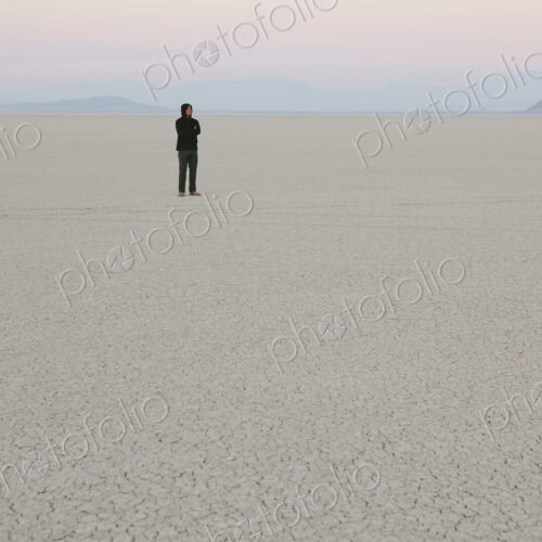 Man standing in vast, desert landscape Man standing in vast, desert landscape