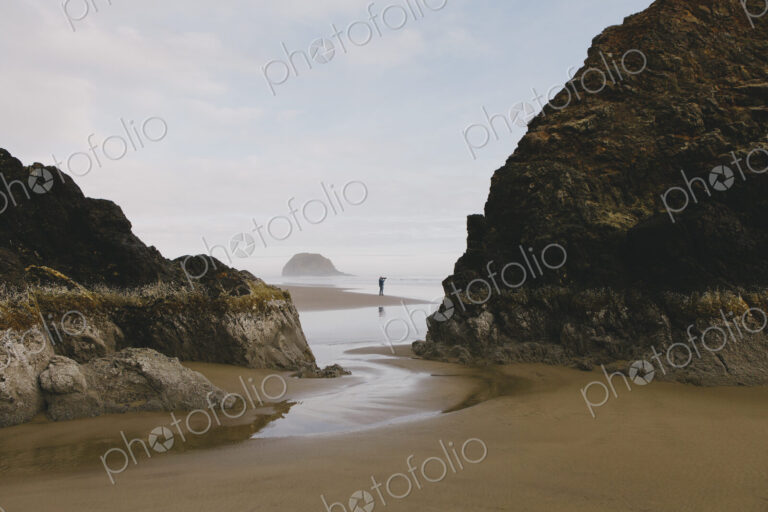 Man taking photographs on a beach at low tide, Arcadia Beach State Park, Oregon