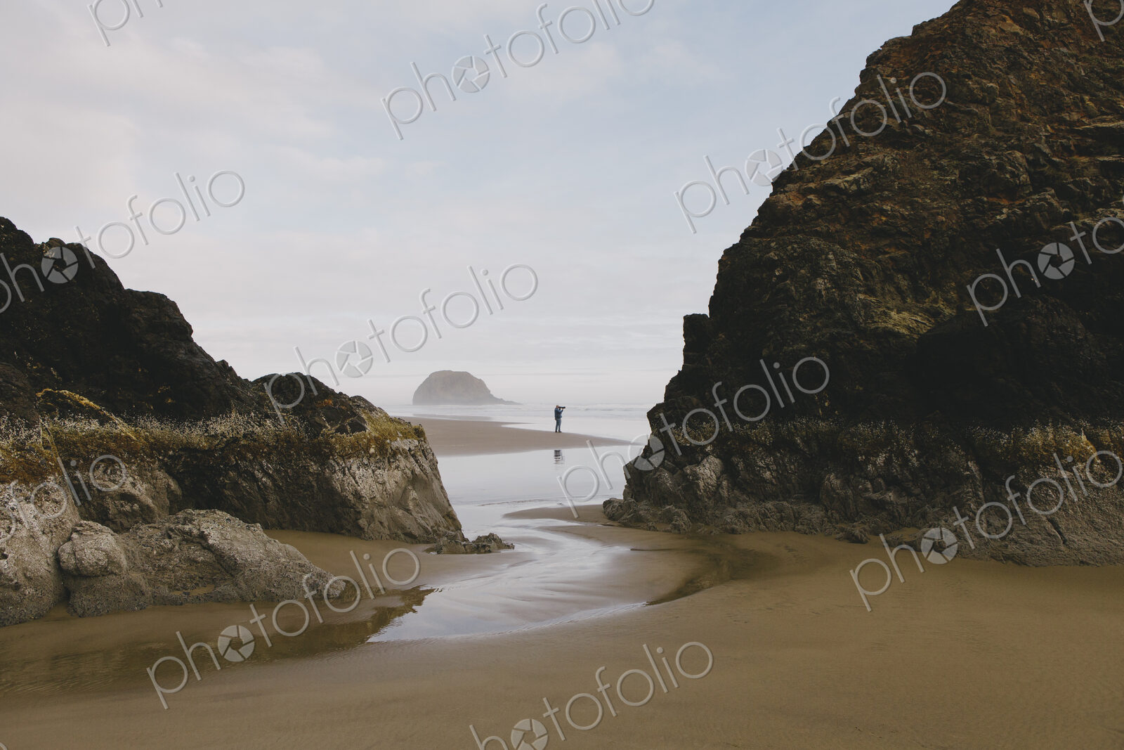 Man taking photographs on a beach at low tide, Arcadia Beach State Park, Oregon