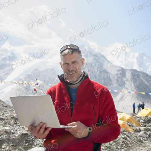 Man using laptop on snowy mountain Man using laptop on snowy mountain