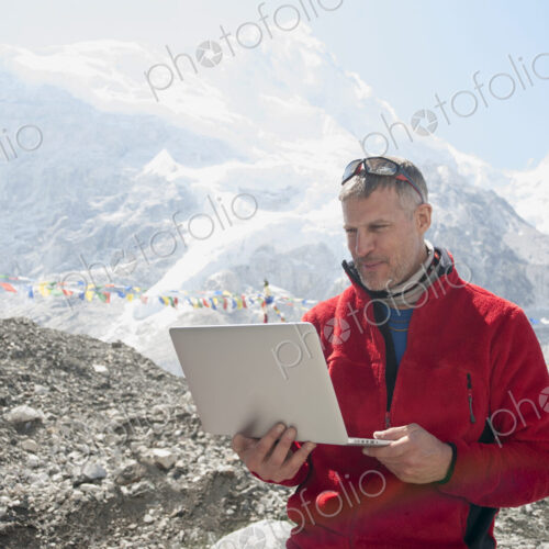 Man using laptop on snowy mountain Man using laptop on snowy mountain