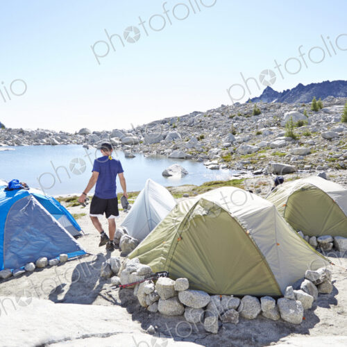 Man walking by tents at campsite in desert landscape Man walking by tents at campsite in desert landscape