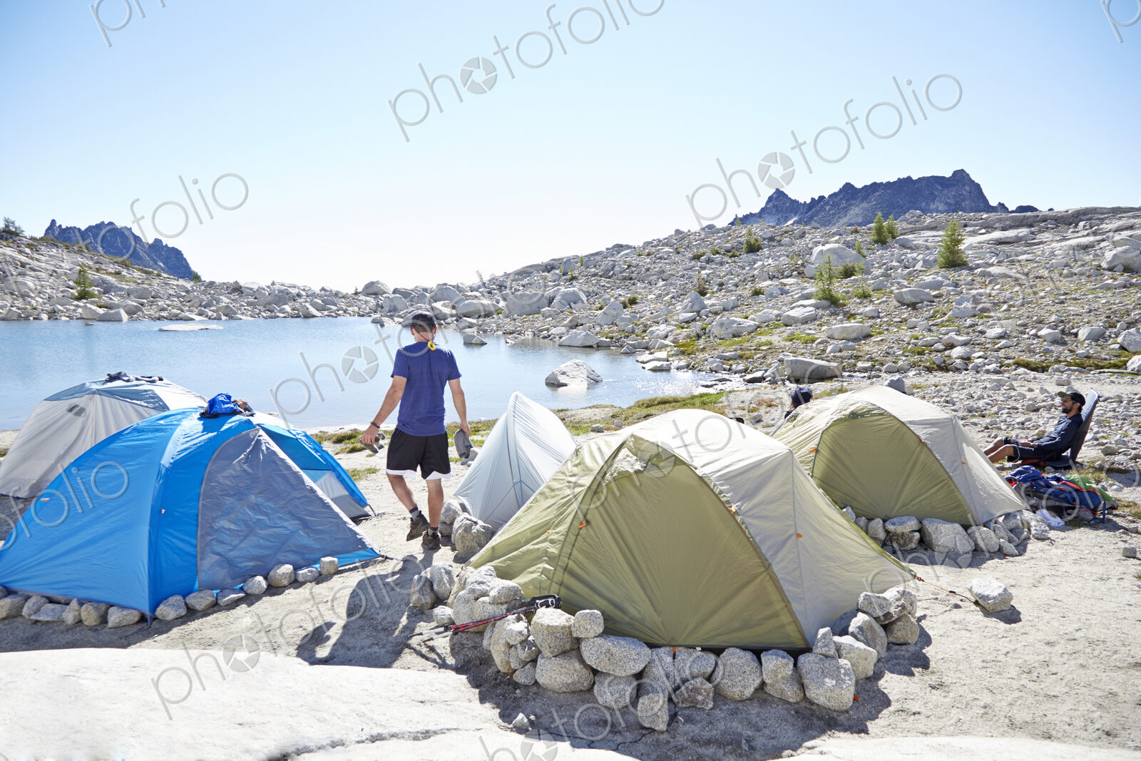 Man walking by tents at campsite in desert landscape