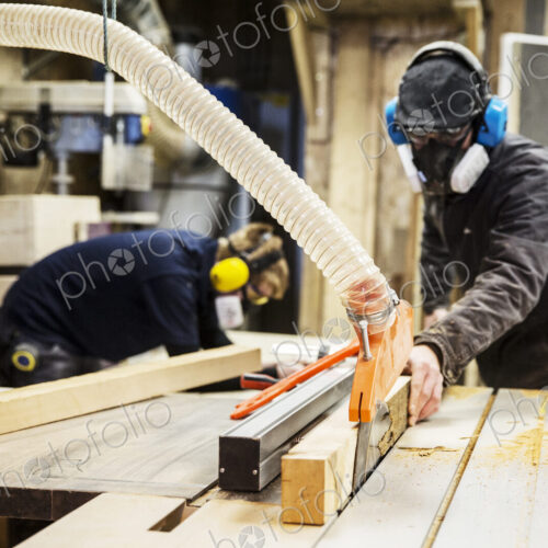 Man wearing ear protectors, protective goggles and dust mask standing in a warehouse,… Man wearing ear protectors, protective goggles and dust mask standing in a warehouse,…