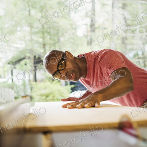 Man wearing glasses working in a lumber yard.