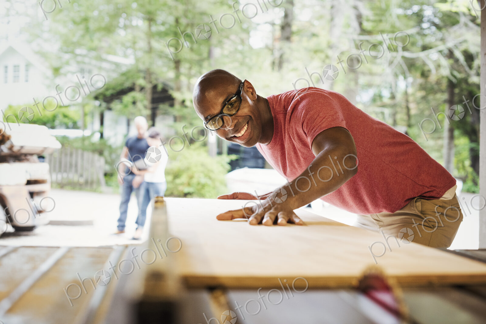 Man wearing glasses working in a lumber yard.