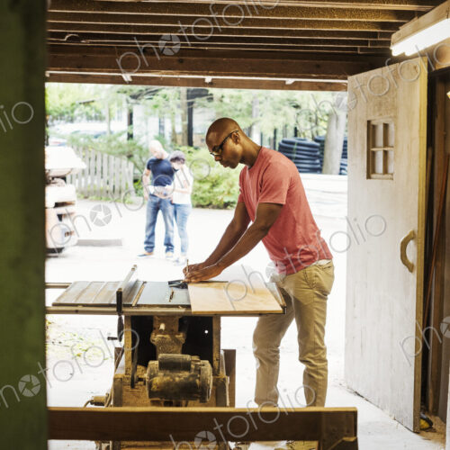 Man wearing glasses working in a lumber yard.