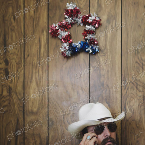 Man with long beard and cowboy hat talking on cell phone. Man with long beard and cowboy hat talking on cell phone.