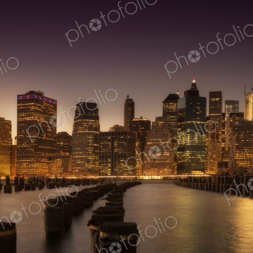 Manhattan skyscrapers lit up at dawn.