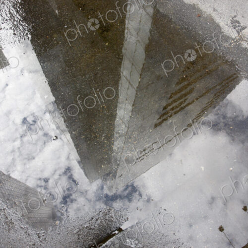 Manhattan skyscrapers reflecting in a rain puddle on the sidewalk. Manhattan skyscrapers reflecting in a rain puddle on the sidewalk.