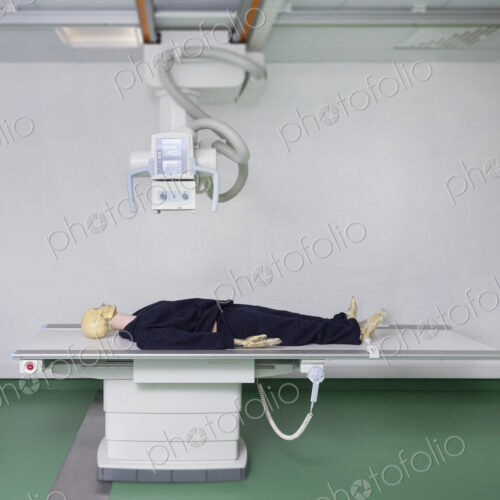 Mannequin lying on a table under an x ray machine in a training college Mannequin lying on a table under an x ray machine in a training college