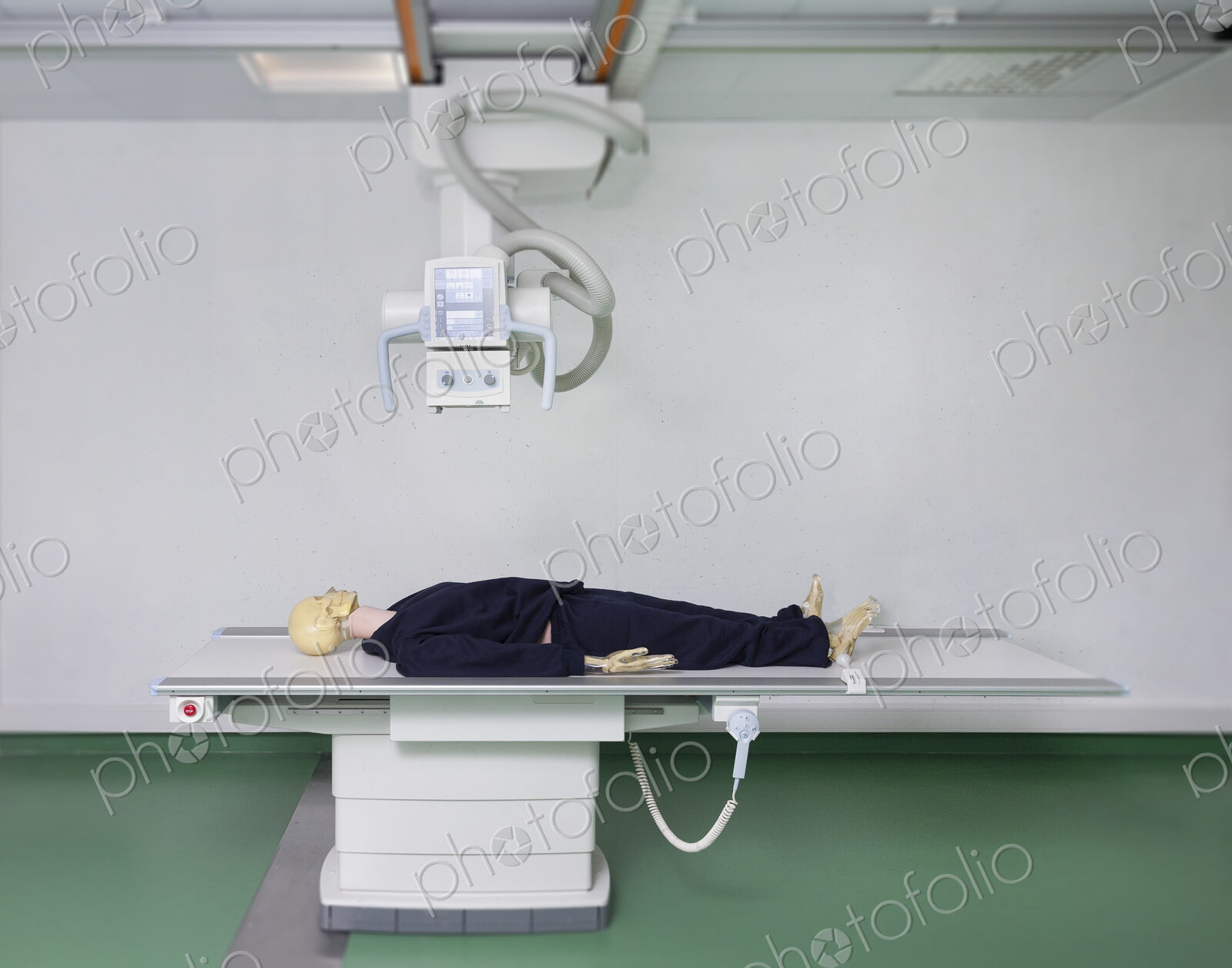 Mannequin lying on a table under an x ray machine in a training college